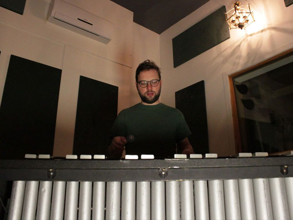 Un musicien devant son vibraphone qui regarde la caméra